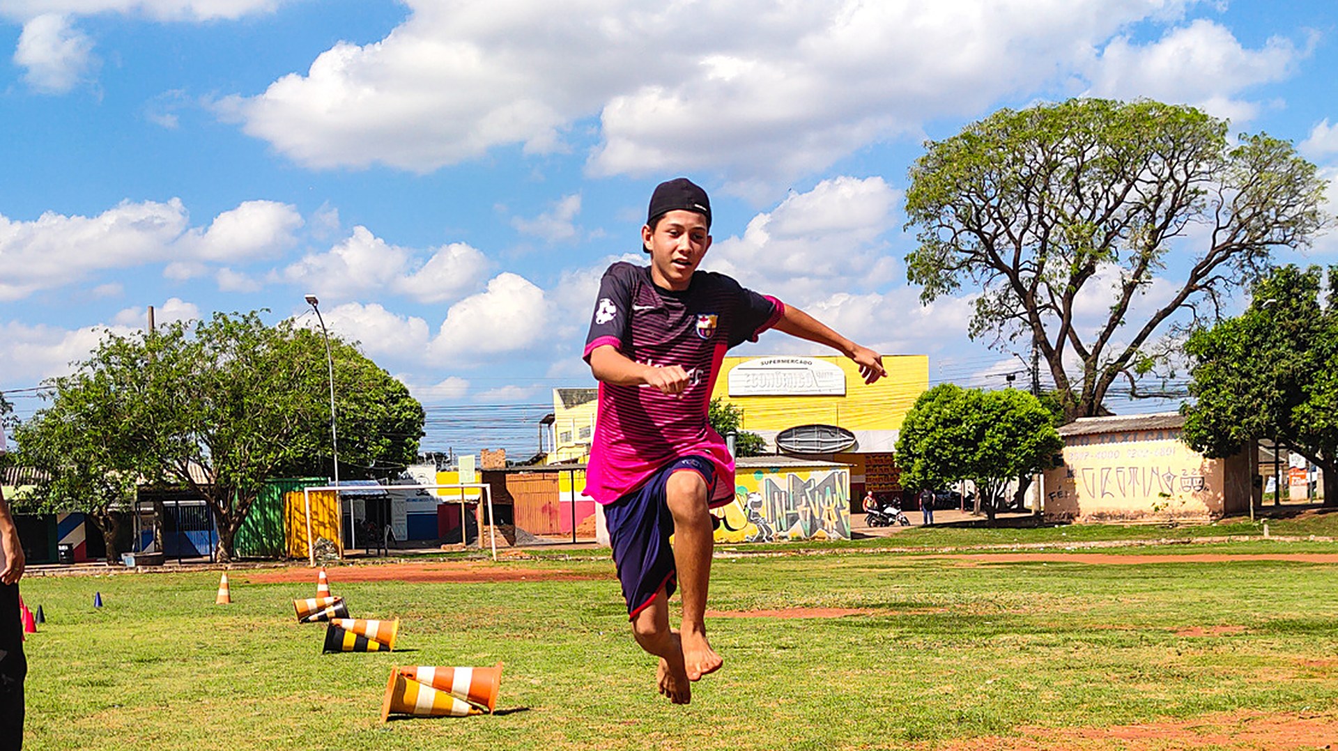 Menino saltando em atividade de atletismo no campo